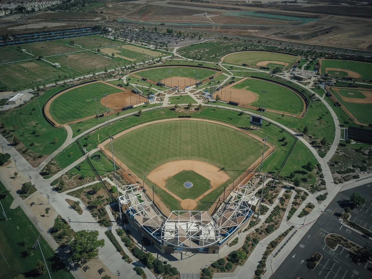 Aerial view of a youth baseball complex with multiple lit diamonds