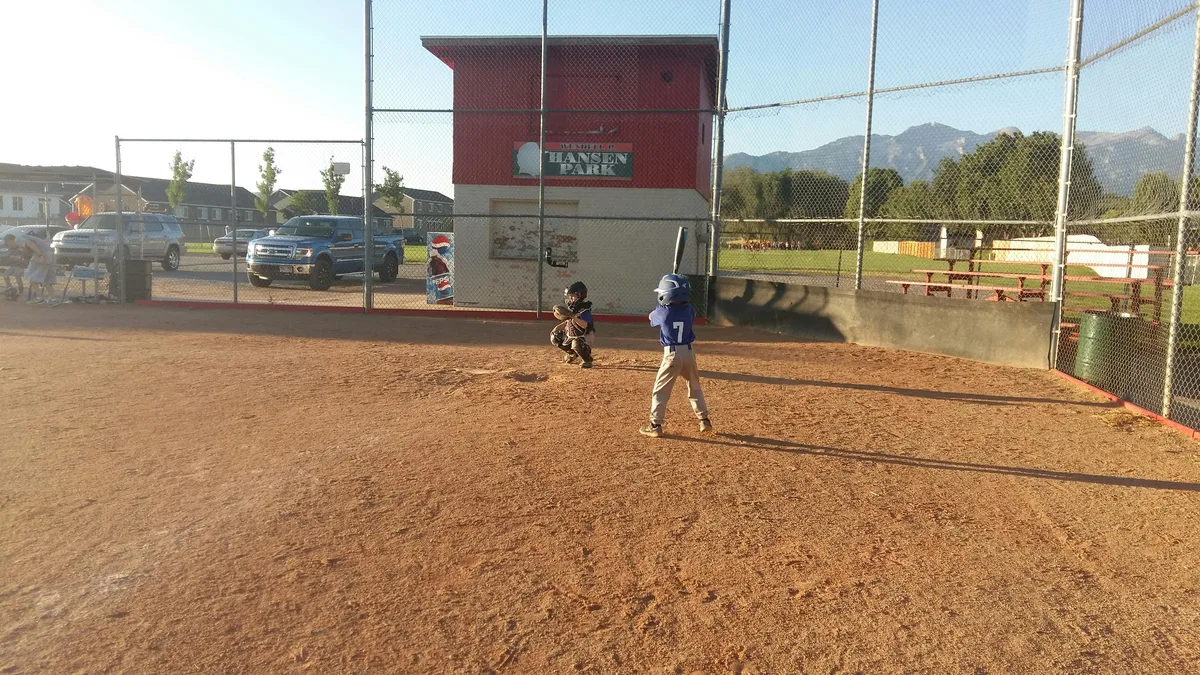 Kids playing youth baseball at an outdoor field
