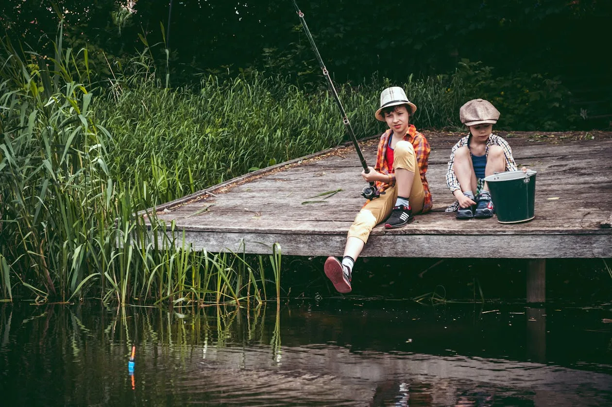 Father and son fishing from a wooden dock