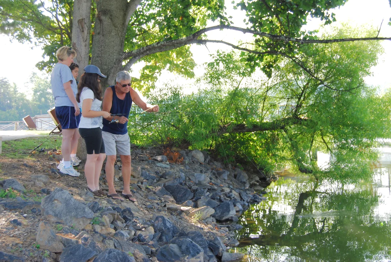 Family fishing from the shore of a calm lake