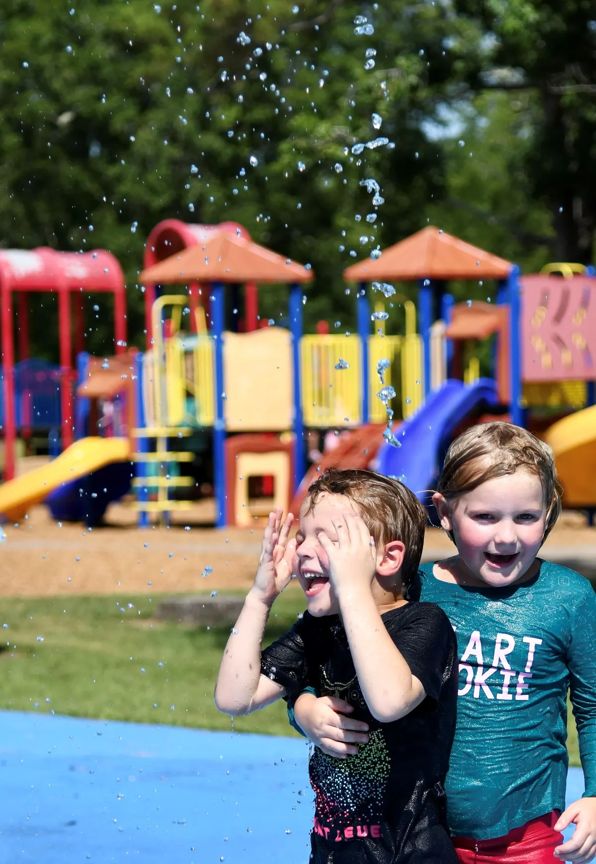 Kids running through water jets at a Beaumont TX city splash pad