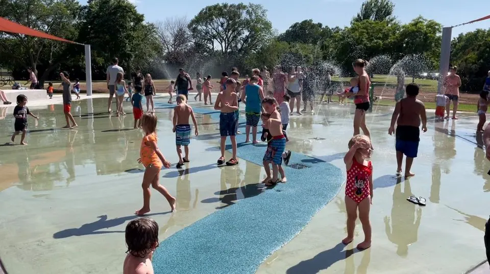 Kids running through ground water jets at Dr.'s Park Splash Pad at Hamilton Park, Wichita Falls TX