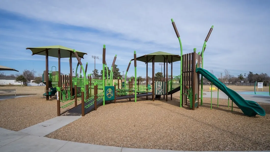 Colorful marsh-themed playground structure with slides and swings at Gene Howe Park — Amarillo, TX