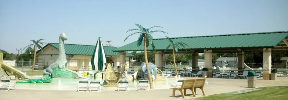 Iowa Park Pool & Spray Park with dinosaur sculptures and palm trees, Iowa Park TX