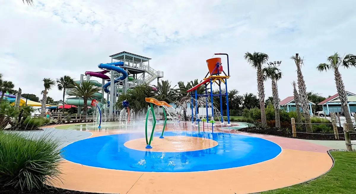 Children playing in a splash pad water park on a sunny summer day