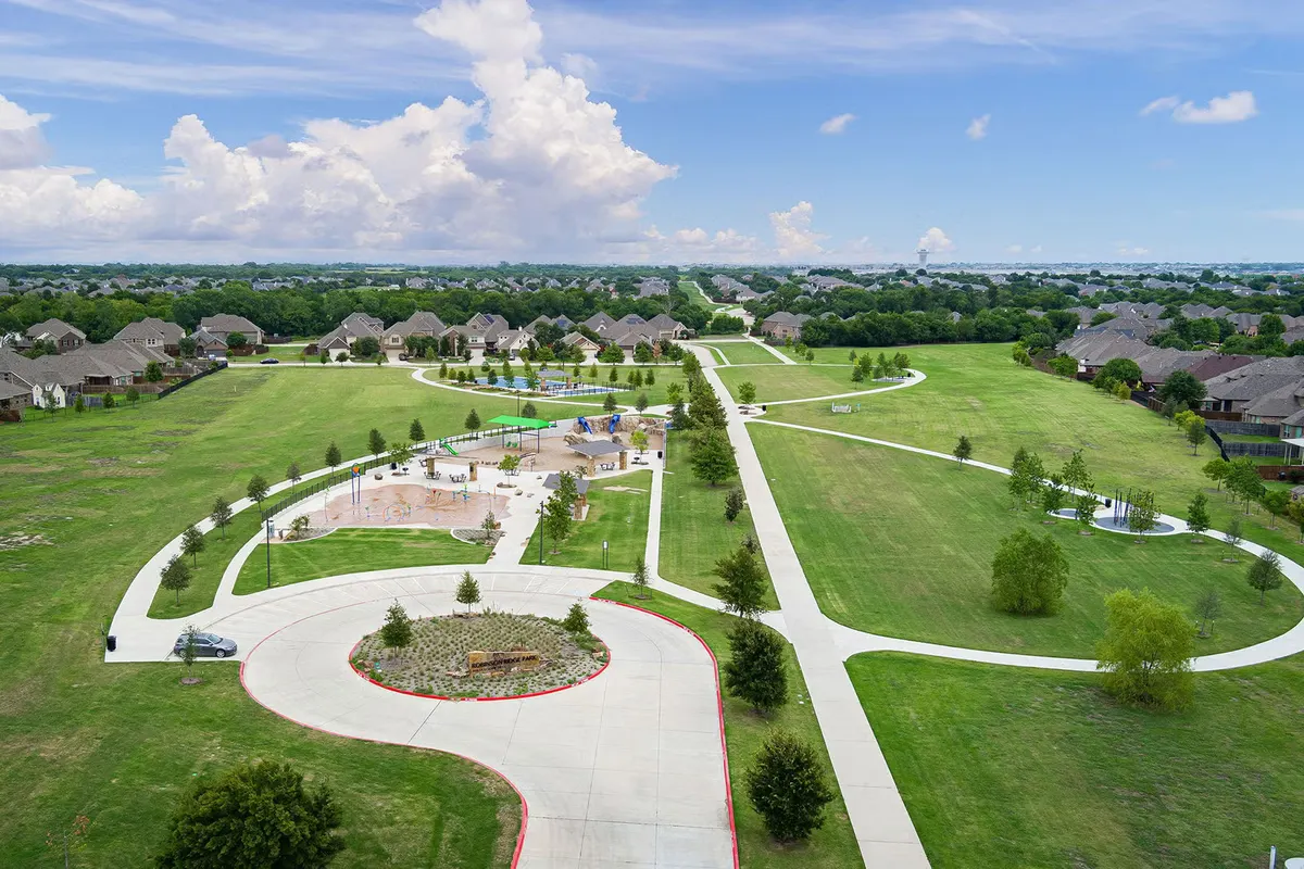 Shaded playground structures and splash pad at Robinson Ridge Park — McKinney, TX