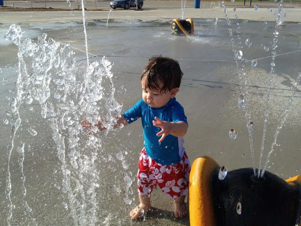 Stamper Park splash pad — child playing in water sprayers, Longview TX