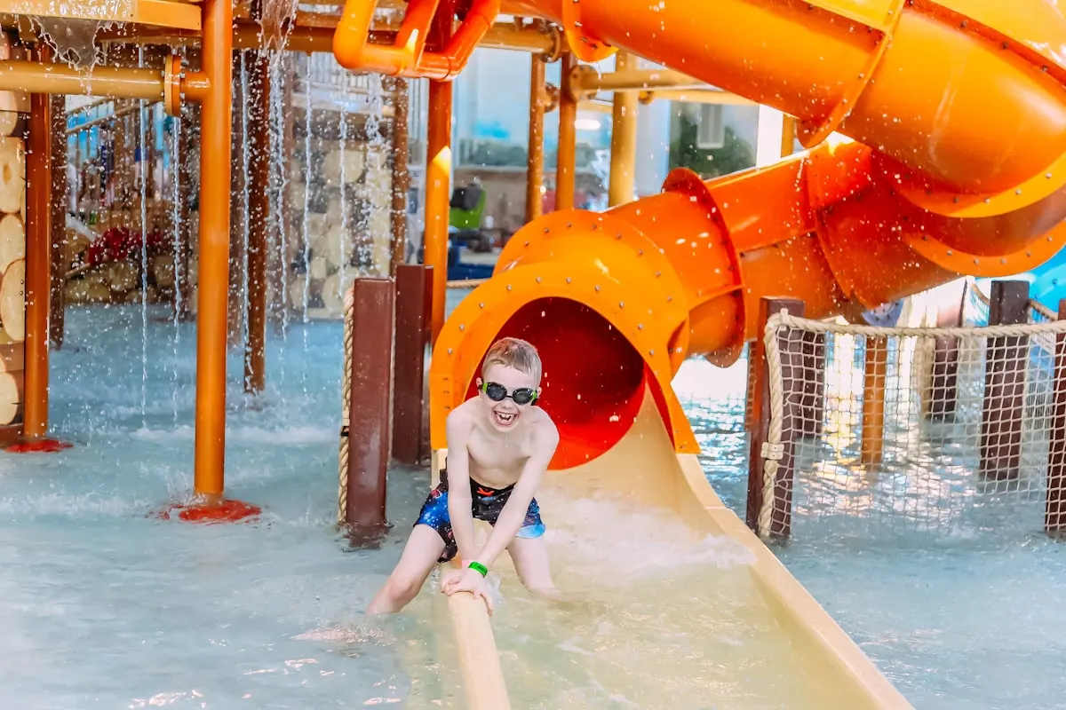 Children playing on a large wooden castle-style playground structure
