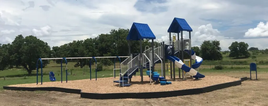 Playground swings and slides at Veterans Memorial Park — Falls City, TX