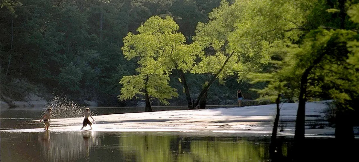 Kids playing by the creek shore at Village Creek State Park playground area — Lumberton, TX