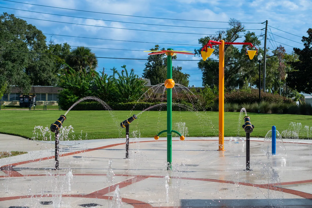 Colorful splash pad with water jets and dumping buckets at Wilson Park, Davenport